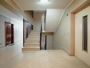 A clean, well-lit hallway with a staircase leading to an upper floor. - DOWNTOWN STYLISH APARTMENT & GARAGE by VACATIONY by Interhome (Porto)