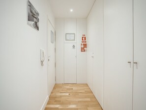 A hallway with a wooden floor, white walls, and a door with a framed certificate. - DOWNTOWN STYLISH APARTMENT & GARAGE by VACATIONY by Interhome (Porto)
