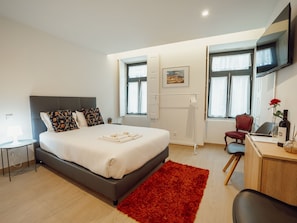 A modern bedroom with a large bed, a desk, a chair, and a red rug. - Apartment  by Interhome (Porto)