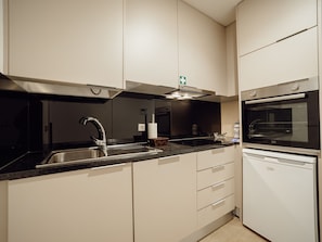 A modern kitchen with a built-in oven, a sink, and a range hood. - Apartment  by Interhome (Porto)