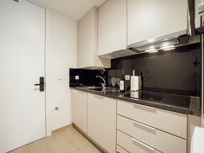A modern kitchen with a black countertop, stainless steel appliances, and light-colored cabinetry. - Apartment  by Interhome (Porto)