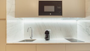 Ett modernt kök med inbyggd mikrovågsugn, kaffebryggare och en diskho med två avdelningar.