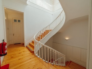 A spiral staircase with wooden steps and white balusters, leading to an upper floor. - Apartment  by Interhome (Porto)