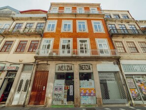 A multi-story building with a ground-floor shop named 'INERZIA' featuring a wooden door and a metal gate. - Apartment  by Interhome (Porto)