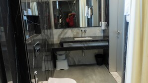 Un baño moderno con una bañera independiente, un tocador con espejo y un inodoro.