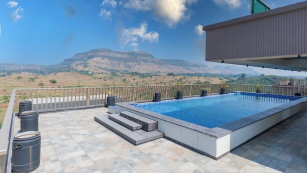 Una piscina en la azotea con vistas a una cadena montañosa.