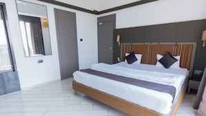 Habitación de hotel moderna con una cama grande, un espejo, un armario y una mesita de noche.