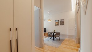 Et moderne interiør med et spiseområde, trægulv og kig ind til et andet rum.