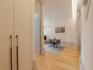 Ein modernes Interieur mit Essbereich, Holzboden und Blick in einen anderen Raum.