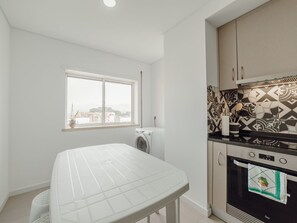Eine Küche mit eingebautem Backofen, einem Fenster und Blick auf die Stadt.