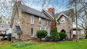 A stone house with a large front yard, a covered porch, and a chimney. - Historic Victorian Cottage, 1 Mi to Niagara Falls (Niagara Falls)
