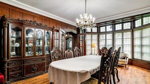 A dining room with a large wooden cabinet, ornate chairs, and a chandelier. - Historic Victorian Cottage, 1 Mi to Niagara Falls (Niagara Falls)