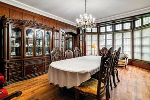 A dining room with a large wooden cabinet, ornate chairs, and a chandelier. - Historic Victorian Cottage, 1 Mi to Niagara Falls (Niagara Falls)