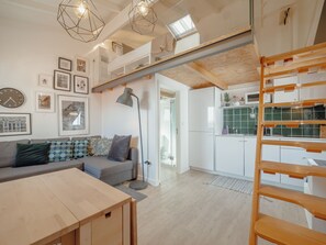 A modern interior with a loft-style kitchen, a dining area, and a living space with a sofa and a coffee table. - Apartment  by Interhome (Porto)