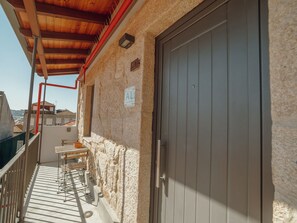 Un balcon doté d’un plafond en bois, d’une porte et d’un mur en pierre.