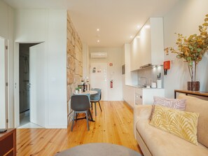 A modern apartment with a dining area, kitchenette, and a living room with a sofa and cushions. - Apartment  by Interhome (Porto)