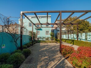 A courtyard with a pergola, a pathway, and a building in the background. - Apartment  by Interhome (Porto)