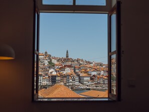 A window view of a cityscape with buildings and a prominent tower. - Apartment  by Interhome (Porto)