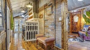 Un intérieur rustique avec un banc en bois, un escalier et un mur orné de motifs.