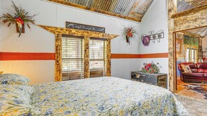 Une chambre à coucher avec une couvre-lit à motifs floraux, des portes en bois, un canapé rouge et un panneau décoratif mural.