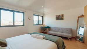 Een hotelkamer met een groot bed, een bank, een bureau en een spiegel.