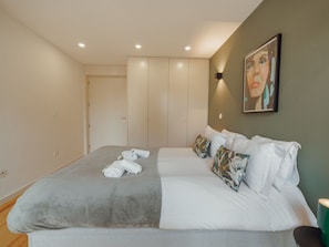 Ein Schlafzimmer mit einem Bett, Kissen und einem Bild an der Wand.