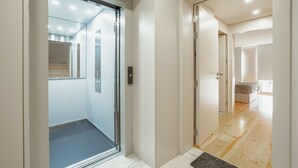 Ein moderner Hotel Eingangsbereich mit Glastür, der zu einem Flur und einem Schlafzimmer führt.