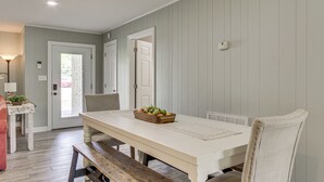 A dining area with a white table, a bench, and a fruit bowl. - Shoals Area Oasis w/ Boat Dock & Outdoor Kitchen (Florence)