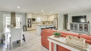 A spacious living area with a kitchen, dining table, and seating. - Shoals Area Oasis w/ Boat Dock & Outdoor Kitchen (Florence)