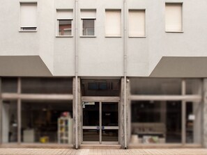 A building facade with a central entrance, multiple windows, and a visible sign for a data systems company. - Apartment  by Interhome (Porto)