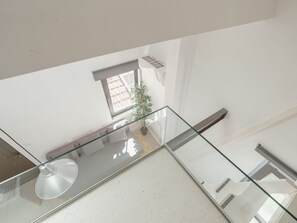 Ein modernes Interieur mit Glastrennwand, einem Blumentopf und einem Fenster mit Außenblick.