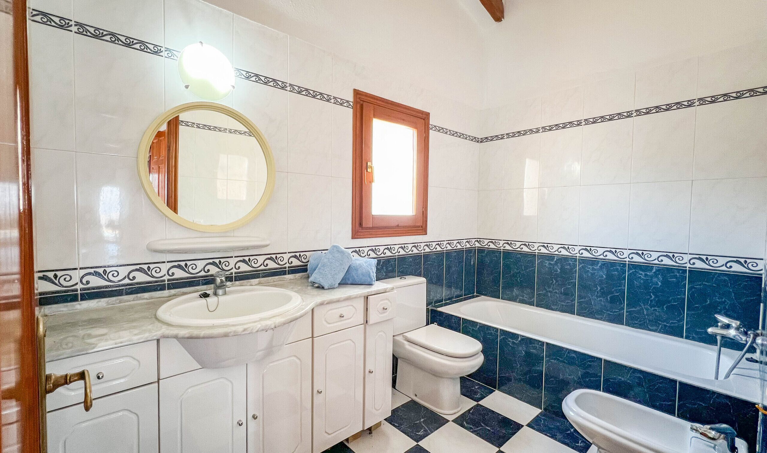 A bathroom with a sink, mirror, toilet, and bathtub.