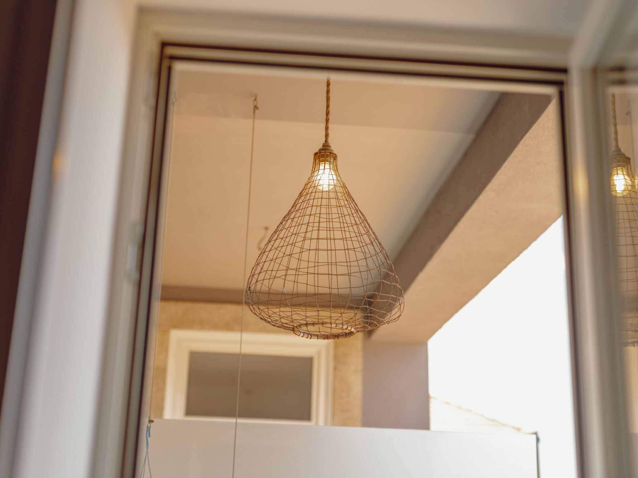A hanging light fixture with a wireframe design.
