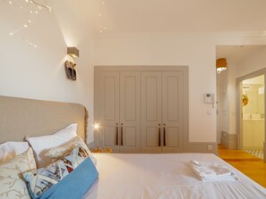 A bedroom with a bed, a wardrobe, and a nightstand. - Apartment  by Interhome (Porto)