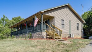 A two-story house with a porch, a staircase, and a flag. - Rural Bybee Retreat w/ Mtn Views! (Bybee)