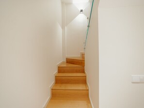 Un escalier avec des marches en bois et des murs blancs.