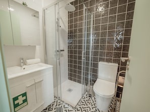 Ein Badezimmer mit Dusche, Toilette und Waschbecken.