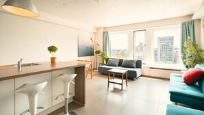 Un appartement moderne comprenant une cuisine, un coin repas et un salon.