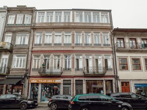 Ein mehrstöckiges Gebäude mit einem Geschäft im Erdgeschoss und Wohnungen in den oberen Stockwerken.