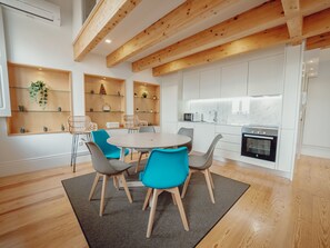 A modern kitchen with white cabinets, a built-in oven, and a microwave. - Apartment  by Interhome (Porto)