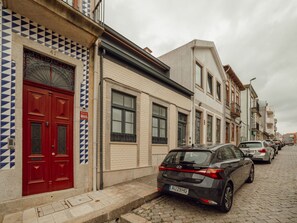 Eine Straße mit geparkten Autos und Gebäuden in traditioneller europäischer Architektur.