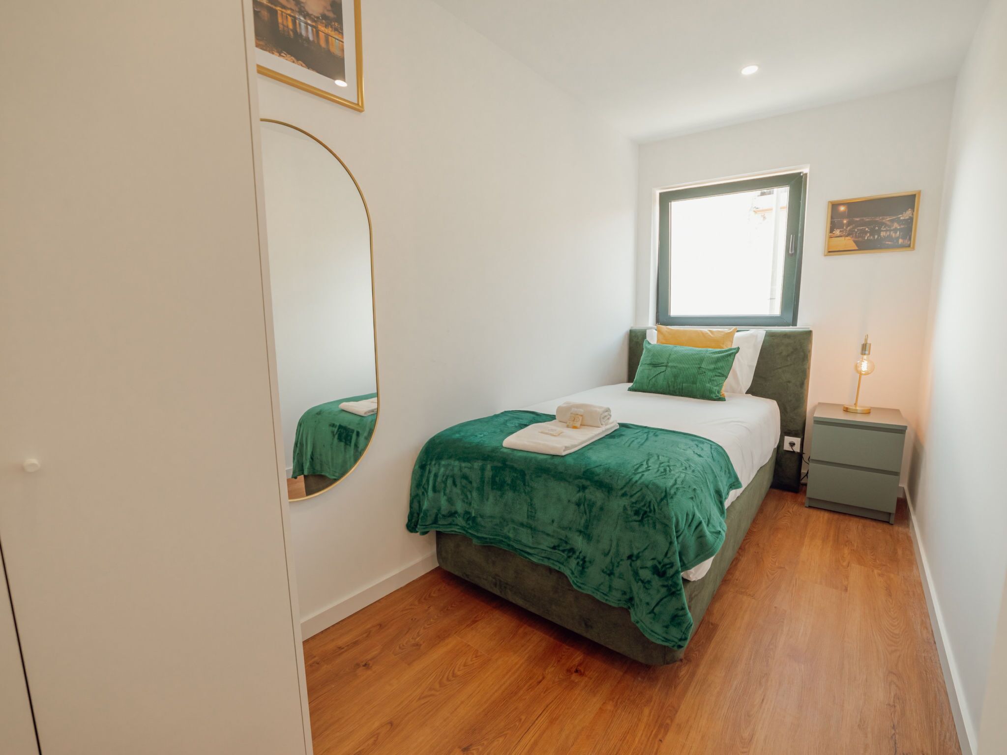 Ein Schlafzimmer mit Bett, Nachttisch und Fenster.