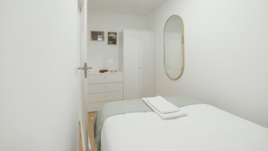 Ein Schlafzimmer mit Bett, Kleiderschrank, Schminktisch und Spiegel.