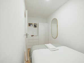 Ein Schlafzimmer mit Bett, Kleiderschrank, Schminktisch und Spiegel.