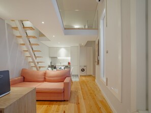 A modern interior with a staircase, a kitchen, and a living area with a sofa. - Apartment  by Interhome (Porto)