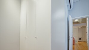 Ein Zimmer mit Schrank, Waschmaschine und einer Tür zu einem weiteren Raum.