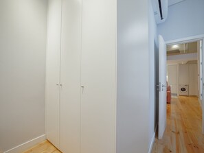 Quarto com guarda-roupa, máquina de lavar e porta que dá para outro espaço.