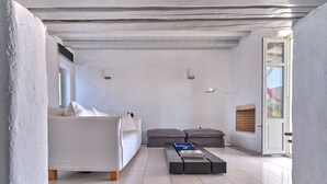 Ein modernes Wohnzimmer mit einer Couch, einem Hocker und einem Couchtisch.