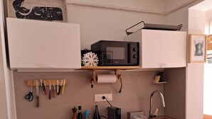 A compact kitchen with a microwave, sink, and wooden countertop. - T2 air-conditioned, Wifi broadband, garden level, Gigaro beach and paths 500m away (La Croix-Valmer)