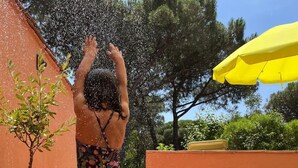 A person standing on a wooden deck with a yellow umbrella in the background. - T2 air-conditioned, Wifi broadband, garden level, Gigaro beach and paths 500m away (La Croix-Valmer)